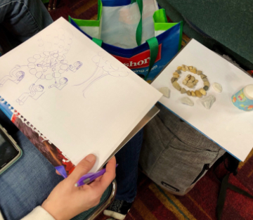 woman drawing a sketch on her lap