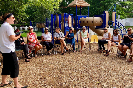 Crystal presenting in front of a group of teachers seated in a circle outside