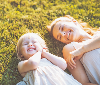mother and child laying in grass